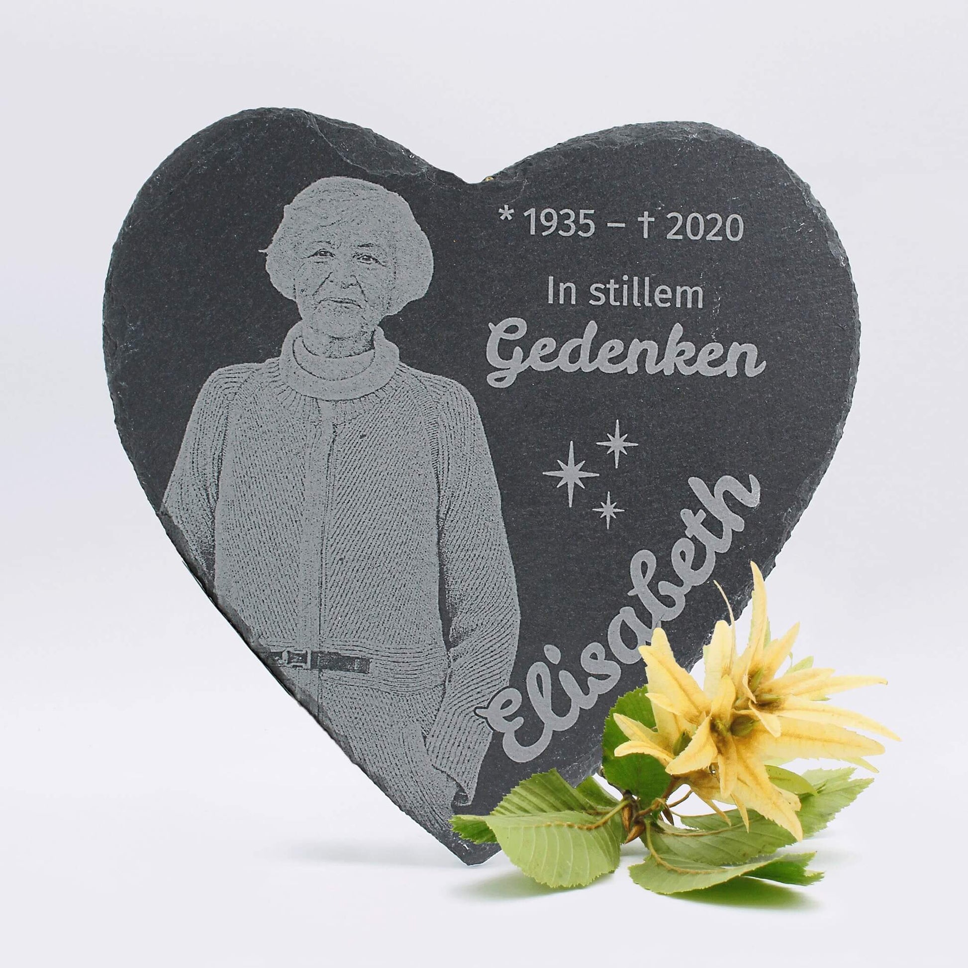 Liebevoll gestaltete Gedenktafel aus Schiefer in Herzform, graviert mit Bild und Namen zur Erinnerung an einen geliebten Menschen.